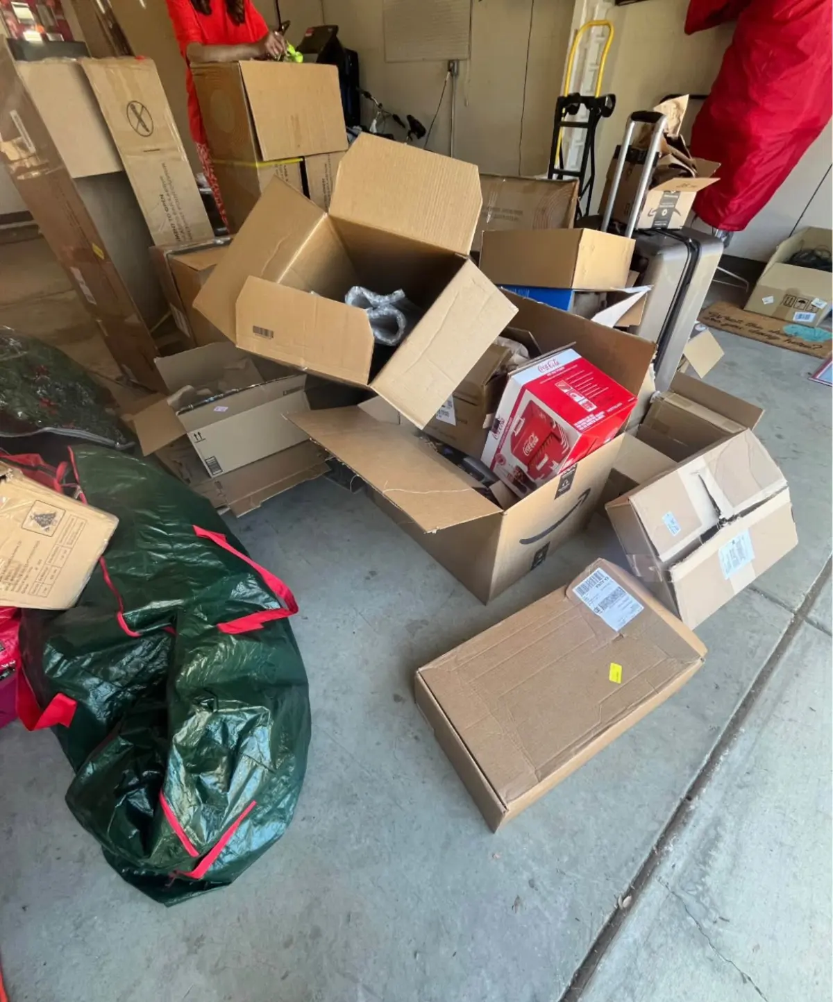 Garage floor covered in open boxes and holiday storage bags