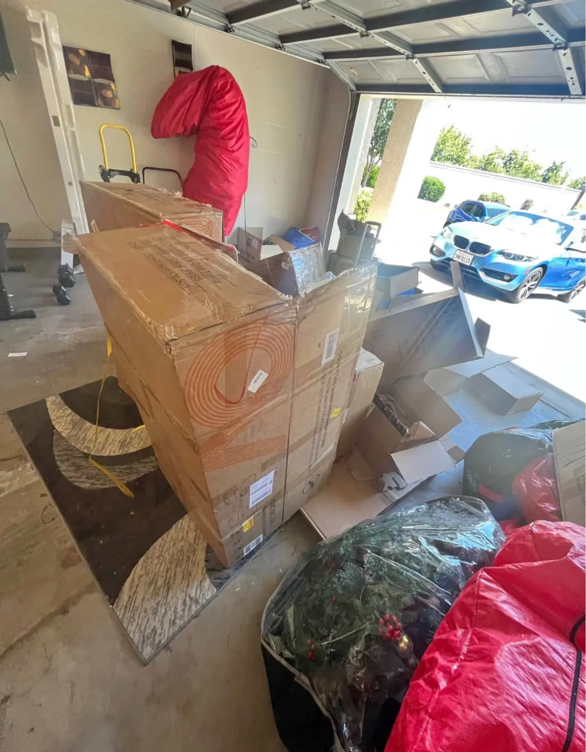 Garage holding boxed furniture, a rug and bags before a cleanout